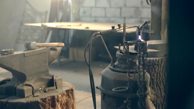 In the forge lit the torch at the anvil