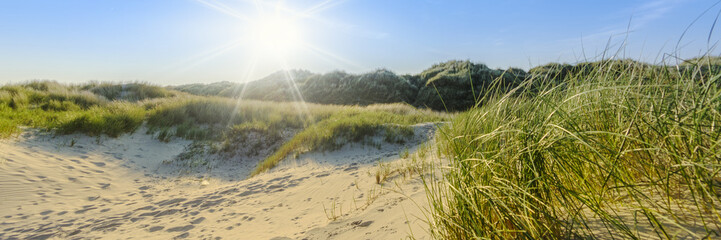 Sommerliche Dünenlandschaft auf norddeutscher Insel mit Sonnenstrahlen | Nordsee - Banner  - 127411015