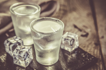 Vodka in shot glasses on rustic wood background
