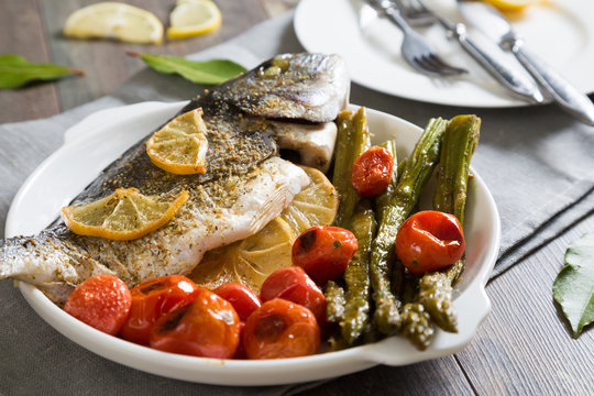 Baked fish with asparagus and cherry tomatoes