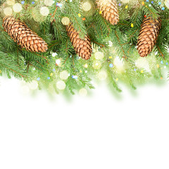 Fresh pine branch with cones and bokeh llights border over white background