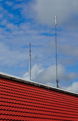 Lightning rod and white color antenna repeater tower on a roof