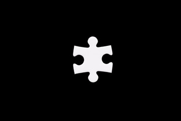 a single white puzzle piece on a black background