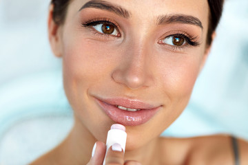Beautiful Woman With Beauty Face Applies Balm On Lips. Skin Care