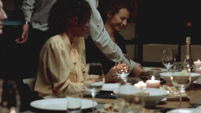Multiethnic group of friends attending a dinner party. 
