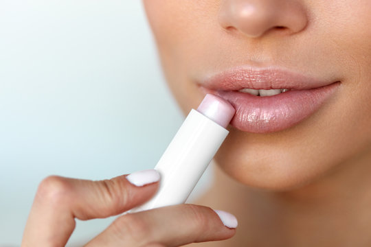 Beautiful Woman Applying Lip Protector On Lips Skin. Beauty