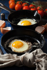 Fried eggs in cast-iron skillets, pepper
