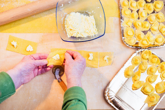 Homemade pasta by elderly woman hands top view image - Grandmother preparing  handmade italian food - Concept of housewife knowledge and old culinary traditions 