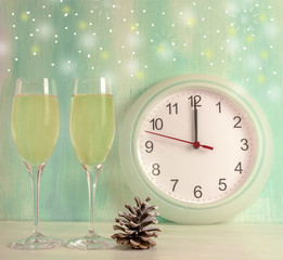 Sparkling wine, pine cone, snowflakes, clock striking midnight, 