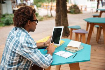 Arfican man using blank screen tablet in outdoor cafe