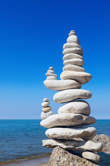Concept of balance and harmony. White rocks zen on the background of sea and blue sky