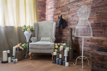Cozy design room with a chair, candles and flowers