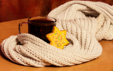 Glass of mulled wine wrapped in scarf and christmas cookie. Selective focus