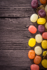 Fototapeta na wymiar Colored fruit candy on wooden background