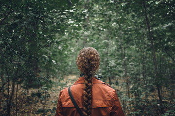 Naklejka premium Young Woman with long hair Walking in Forest. Back View, dramatic image concepte