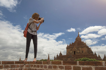 female traveler photographing temples at Bagan Myanmar Asia at sunrise