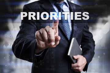 Businessman is pressing button on touch screen interface and selecting priorities.