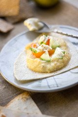Delicious hummus on blue plate with the fresh vegetables.