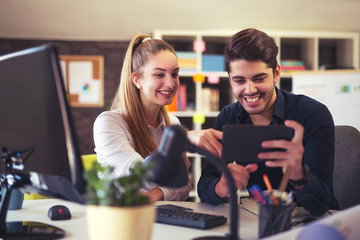 Couple of web designers working together at modern office using digital tablet