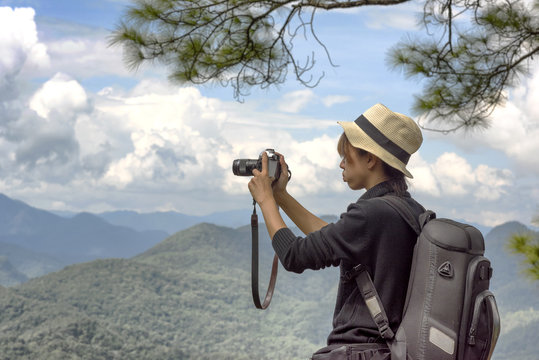 Woman traveling backpack her take a photo with mountain
