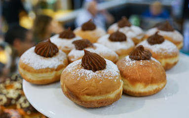 Fresh donuts on bakery display for Hanukkah celebration. Selective focus.