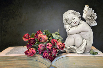 Condolence card with angel, roses and old book on grunge background