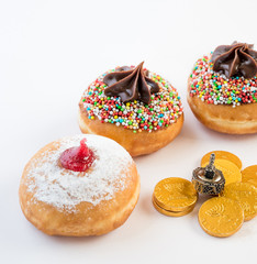 Fresh donuts, chocolate coins and silver dreidel for Hanukkah celebration. 