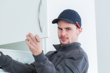 Man fitting kitchen cupboard