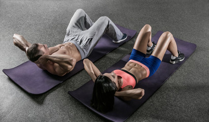 Fitness. Young fit man and woman exercising in a gym