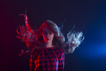 Woman with long curly hair in motion at studio