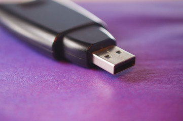 Black flash drive on a purple surface