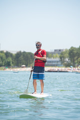man enjoying a ride on the lake with paddleboard