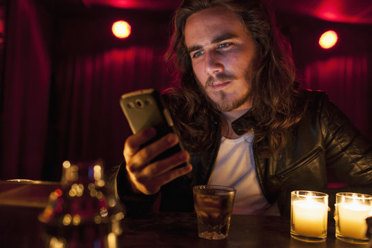 Young man checking his cell phone while at a nightclub