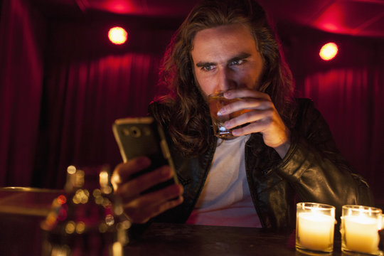 Young man checking his cell phone while at a nightclub