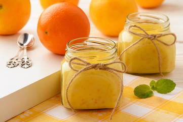 Orange curd (english citrus cream) in glass jars.