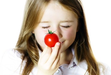 Little girl showing small red tomato