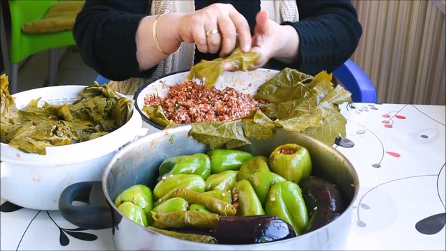 Turkish woman making Sarma - Traditional Turkish food. Grape leaves stuffed with rice and minced meat.