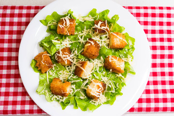 Caesar salad with croutons on a white plate