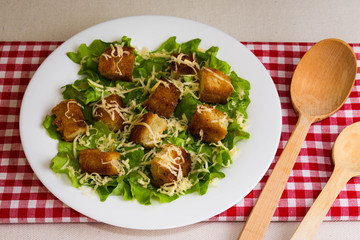 Caesar salad with croutons on a white plate