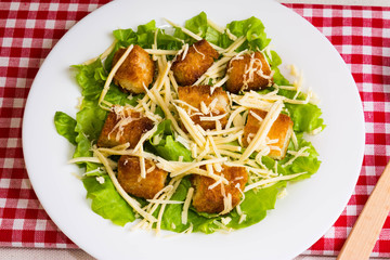 Caesar salad with croutons on a white plate