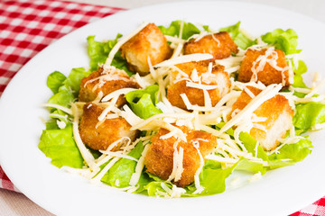 Caesar salad with croutons on a white plate