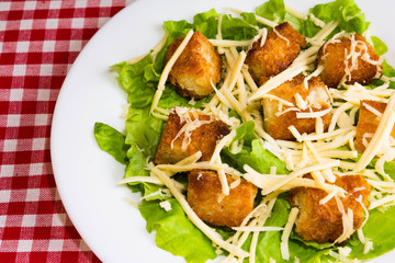 Caesar salad with croutons on a white plate