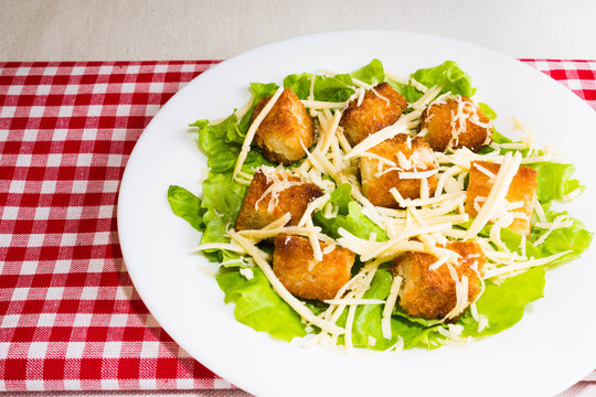 Caesar salad with croutons on a white plate