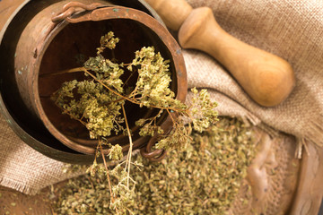 Antique metallic dish and pot with dried oregano.