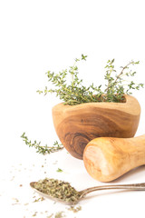 Fresh thyme in  wooden mortar with pestle, on withe background.
