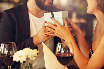 Romantic couple with present in restaurant