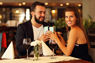 Romantic couple with present in restaurant