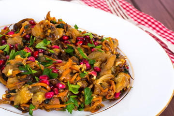 Baked eggplant with pomegranate seeds and herbs closeup