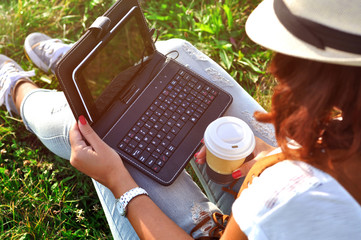 Relaxation with a cup of coffee and tablet.Girl with laptop an coffee. Beautiful young woman with...