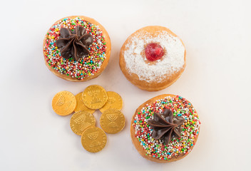 Fresh donuts  and chocolate coins for Hanukkah celebration. 